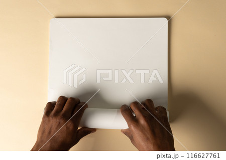 Biracial man opening a laptop on a desk, with copy space 116627761