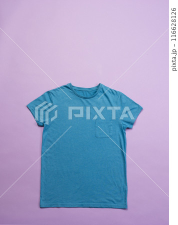 A blue t-shirt is laid out flat against a pink background, with copy space 116628126