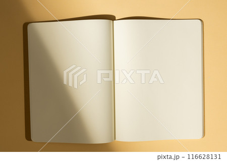 Open blank notebook on a beige surface, with copy space 116628131