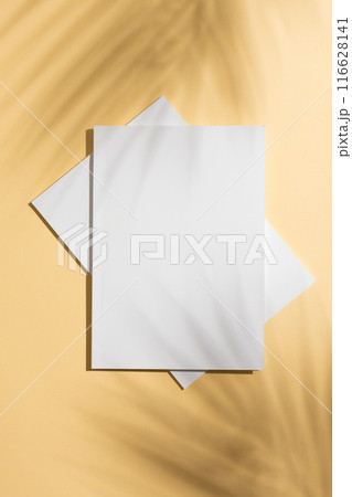 Blank white magazines lie on a yellow background, with copy space 116628141