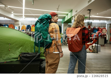 Happy loving couple choosing backpacks for hiking and travel tour on weekend Happy loving couple choosing backpacks for hiking and travel tour on weekend 116628515