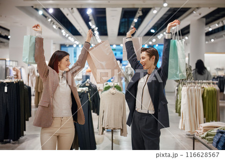 Happy female friends celebrating good shopping day 116628567