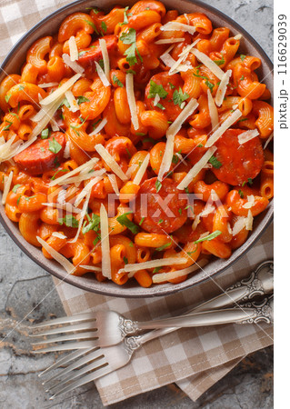 One Pot Gochujang Pasta with cheddar and parmesan cheese and sausages closeup on the plate. Vertical top view One Pot Gochujang Pasta with cheddar and parmesan cheese and sausages closeup on the plate. Vertical top view 116629039