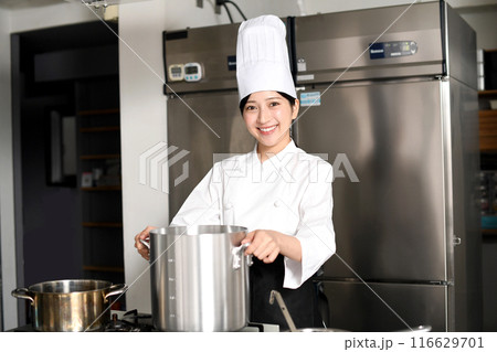 寸胴鍋で調理する若いアジア人の女性調理師 116629701
