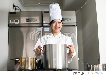 寸胴鍋で調理する若いアジア人の女性調理師 寸胴鍋で調理する若いアジア人の女性調理師 116629707