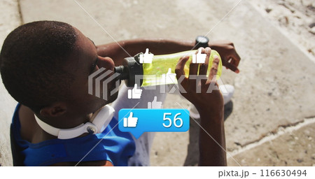 Image of like icons with numbers over african american male athlete with bottle using phone 116630494