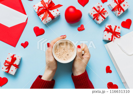 Flat lay of heart shaped cup of black coffee in the hands of women on colored background with copy space top view. Valentine day and holiday concept Flat lay of heart shaped cup of black coffee in the hands of women on colored background with copy space top view. Valentine day and holiday concept 116631310