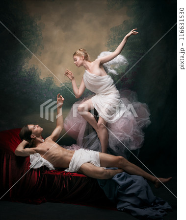 Elegant man and woman in period attire showing affection to each other against dark vintage background. Eternal love Elegant man and woman in period attire showing affection to each other against dark vintage background. Eternal love 116631530