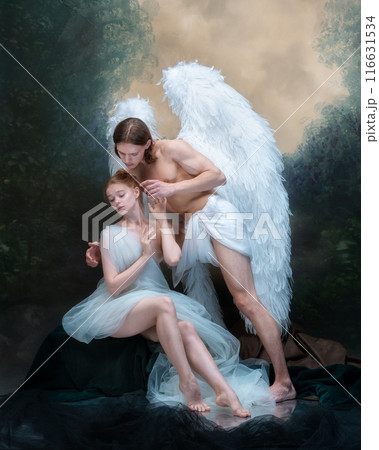 Tender scene of two angelic characters, man with wings hugging woman against vintage green background. Protection, love, and trust. 116631534