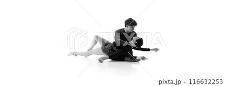 Banner. Ballet duo in fluid pose on floor with grace and precision against white studio background with negative space. Sepia filter. Banner. Ballet duo in fluid pose on floor with grace and precision against white studio background with negative space. Sepia filter. 116632253