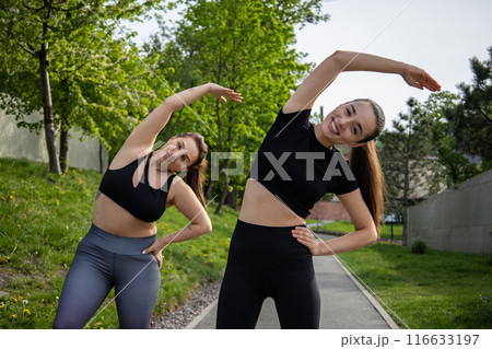 Woman with overweight warming up and exercising for dieting and health with her trainer in park Woman with overweight warming up and exercising for dieting and health with her trainer in park 116633197