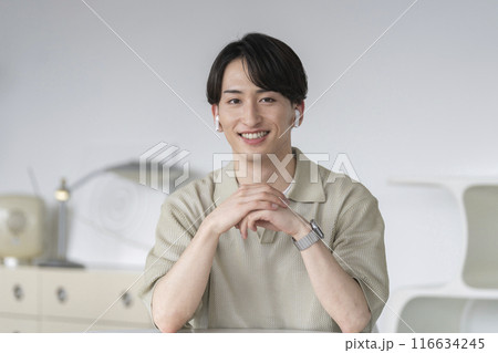 カメラ目線のイヤホンをした20代前半の男性 116634245