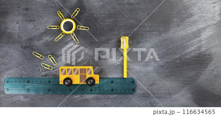Back to school concept. Imitation of trip to school on school bus. Pencils, ruler, sharpener, toy bus on black background. Top view Back to school concept. Imitation of trip to school on school bus. Pencils, ruler, sharpener, toy bus on black background. Top view 116634565
