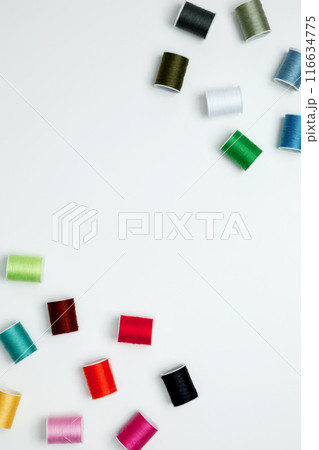 Multicolored sewing threads on white background. Top view, copy space Multicolored sewing threads on white background. Top view, copy space 116634775