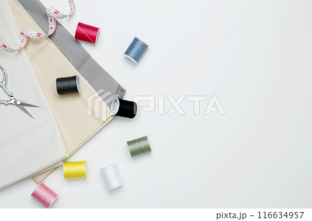 Composition with various threads and sewing accessories on white background. Top view, copy space Composition with various threads and sewing accessories on white background. Top view, copy space 116634957
