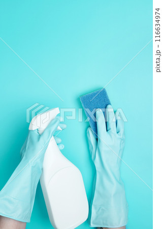 Womans hand in rubber glove holds yellow dishwashing sponge and cleaning product. House cleaning. Copy space Womans hand in rubber glove holds yellow dishwashing sponge and cleaning product. House cleaning. Copy space 116634974