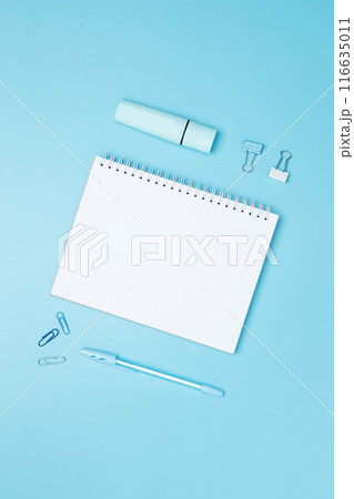 Creative flat lay mockup design of workspace. Top view composition with white notebook, to do list and stationery on blue background Creative flat lay mockup design of workspace. Top view composition with white notebook, to do list and stationery on blue background 116635011