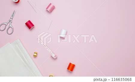 Composition with various threads and sewing accessories on pink background. Top view, copy space Composition with various threads and sewing accessories on pink background. Top view, copy space 116635068