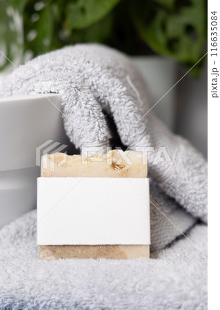 Soap bar with blank label on grey towels near vessel sink and green plant close up, mockup Soap bar with blank label on grey towels near vessel sink and green plant close up, mockup 116635084