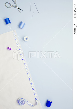 Composition with various threads and sewing accessories on blue background. Top view, copy space 116635283