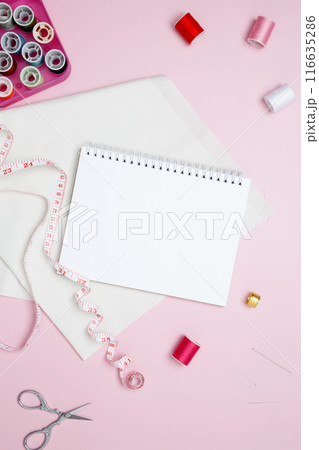 Composition with various threads and sewing accessories on pink background. Mock up notebook Composition with various threads and sewing accessories on pink background. Mock up notebook 116635286