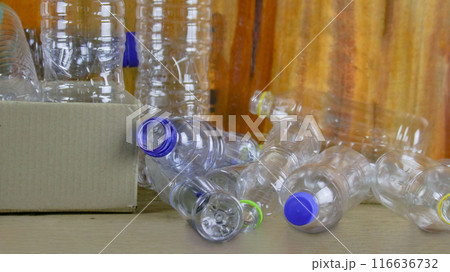 Waste plastic bottles on wooden background waiting for recycling concept of saving our environment sustainable natural resources. 116636732