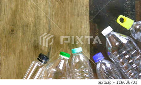Waste plastic bottles on wooden background waiting for recycling concept of saving our environment sustainable natural resources. 116636733