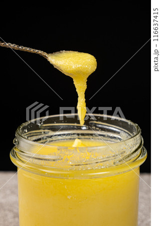 Natural ghee healthy lactose-free oil for frying, black background Natural ghee healthy lactose-free oil for frying, black background 116637415