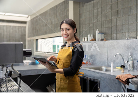 Young Barista in Modern Coffee Shop Holding Tablet and Smiling at Camera Young Barista in Modern Coffee Shop Holding Tablet and Smiling at Camera 116638022