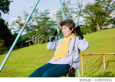 童心に帰ってブランコを楽しむシニア女性 童心に帰ってブランコを楽しむシニア女性 116638161