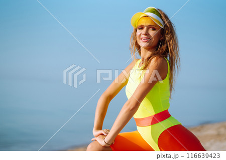 Three young woman in bright swimsuits dancing. Sport, summer, fitness, urban culture concept. Three young woman in bright swimsuits dancing. Sport, summer, fitness, urban culture concept. 116639423