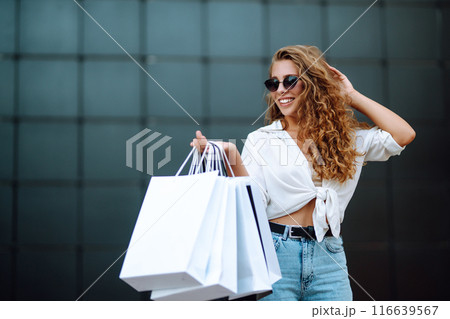 Woman in shopping. Woman with shopping bags walking around city after shopping. Lifestyle concept. Woman in shopping. Woman with shopping bags walking around city after shopping. Lifestyle concept. 116639567