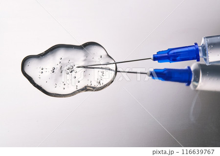A drop of medicine flowing from a syringe with a needle. A drop of medicine flowing from a syringe with a needle. 116639767