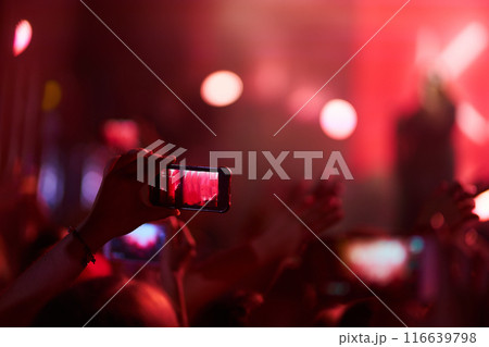 Hand with a phone records live music festival. People taking photographs with smart phone during concert. 116639798