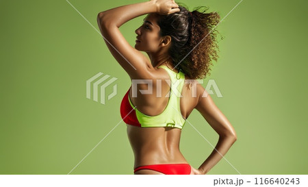 Middle Eastern female from behind in a sporty red neoprene bikini vibrant lime studio background 116640243