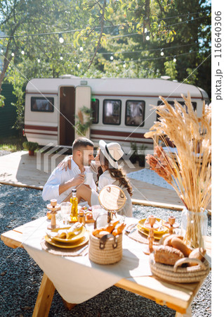 Beautiful wedding couple laugh and kiss relaxing in rv, camping in a trailer. Romantic moment. 116640306
