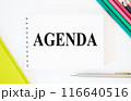 Top view of pen and notebook written with Agenda on white background with folder and pencils. Agenda Meeting Appointment Activity Information Concept, agenda word. bright picture 116640516