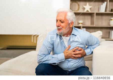 Pain on heart, heart attack. Unhappy middle aged senior man suffering from chest pain heart attack problems with health at home. Mature old senior grandfather touching chest experiencing infarction Pain on heart, heart attack. Unhappy middle aged senior man suffering from chest pain heart attack problems with health at home. Mature old senior grandfather touching chest experiencing infarction 116640656