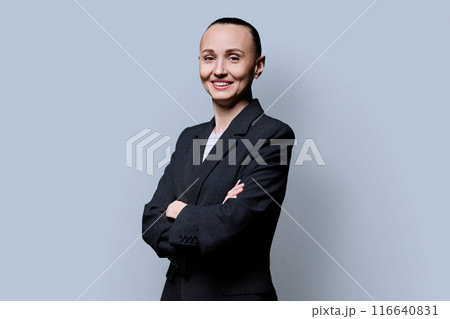 Portrait of smiling business 30s woman with crossed arms on grey background Portrait of smiling business 30s woman with crossed arms on grey background 116640831