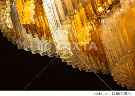 Shiny yellow glass decoration of a luxury vintage chandelier. Close-up Shiny yellow glass decoration of a luxury vintage chandelier. Close-up 116640876