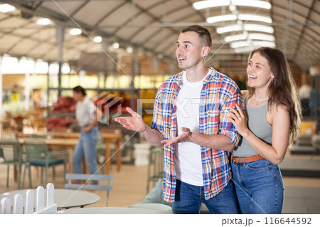 Friendly couple looking for comfortable furniture in garden store 116644592