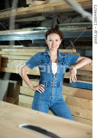 Woman employee of carpentry workshop took time out from work, stands resting Woman employee of carpentry workshop took time out from work, stands resting 116644673