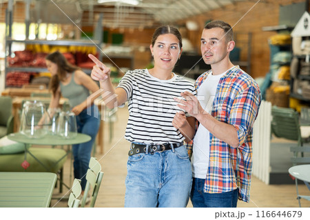 Interested couple looking for functional furniture in garden store Interested couple looking for functional furniture in garden store 116644679