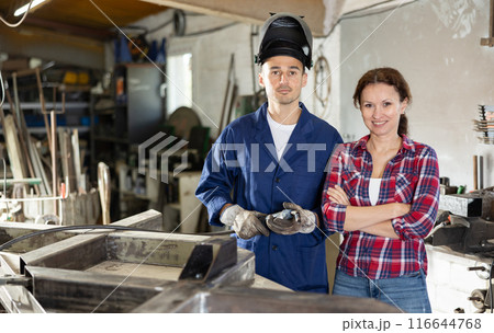 Man trains woman to do connecting iron rails with welding machine. Man trains woman to do connecting iron rails with welding machine. 116644768