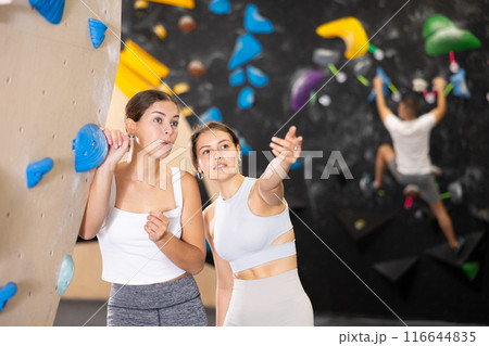 Two young women talking near climbing wall 116644835