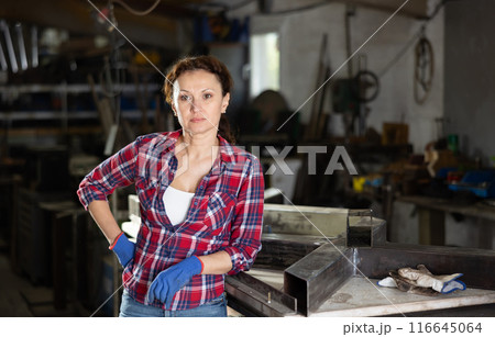 Adult woman posing in oak workshop Adult woman posing in oak workshop 116645064