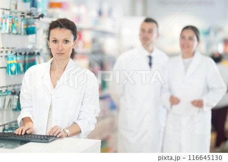Adult female pharmacist poses at computer in pharmacy 116645130