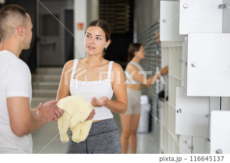 Young man and woman talking in locker room 116645137