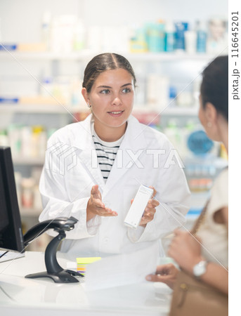 Female pharmacist giving prescription medicine to adult woman Female pharmacist giving prescription medicine to adult woman 116645201