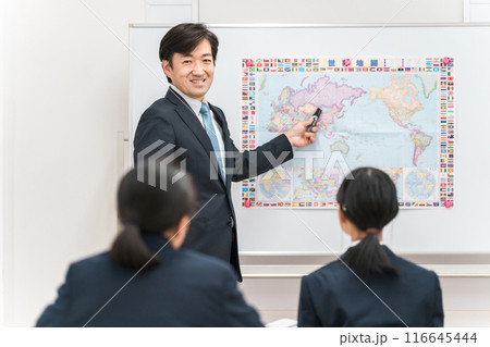 塾・学校の教室で中学生の子供に勉強を教える男性講師・教師 116645444